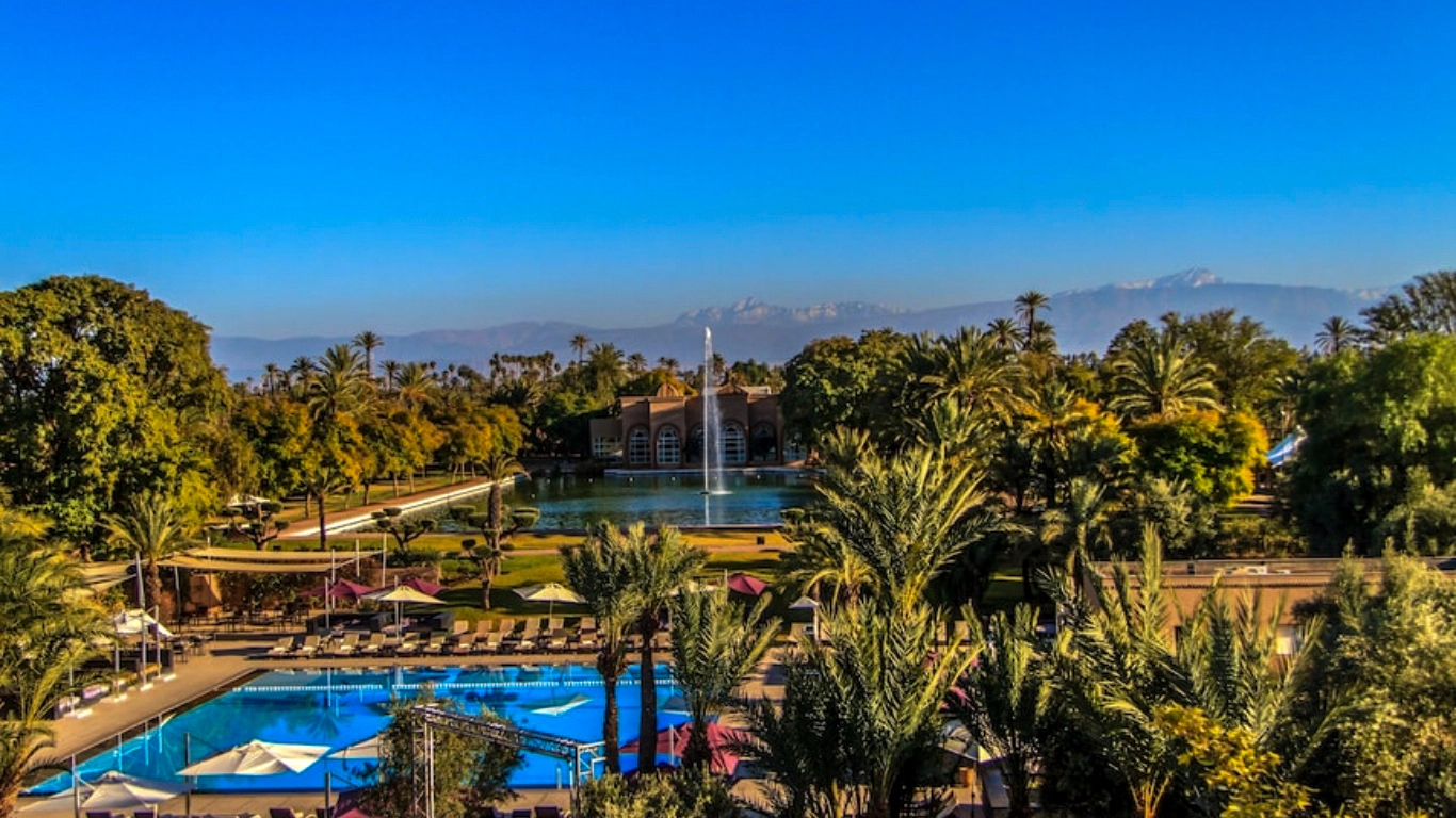 Barcelo Palmeraie Oasis Resort Marrakech outdoor pool, lush gardens, and Atlas Mountains view