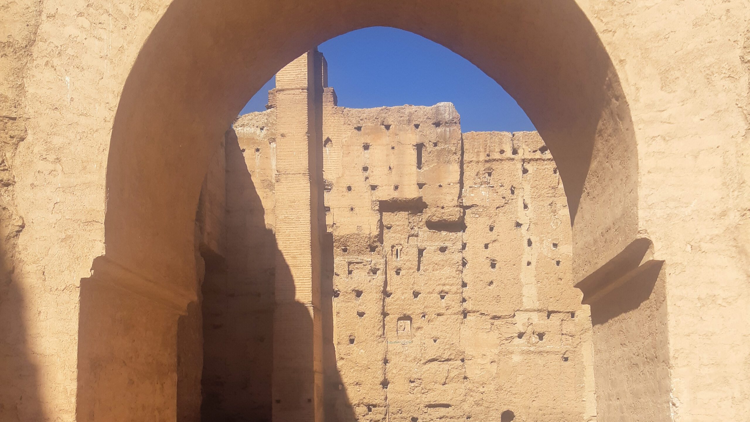 View through an archway at El Badi Palace in Marrakech, highlighting the ancient architecture and ruins