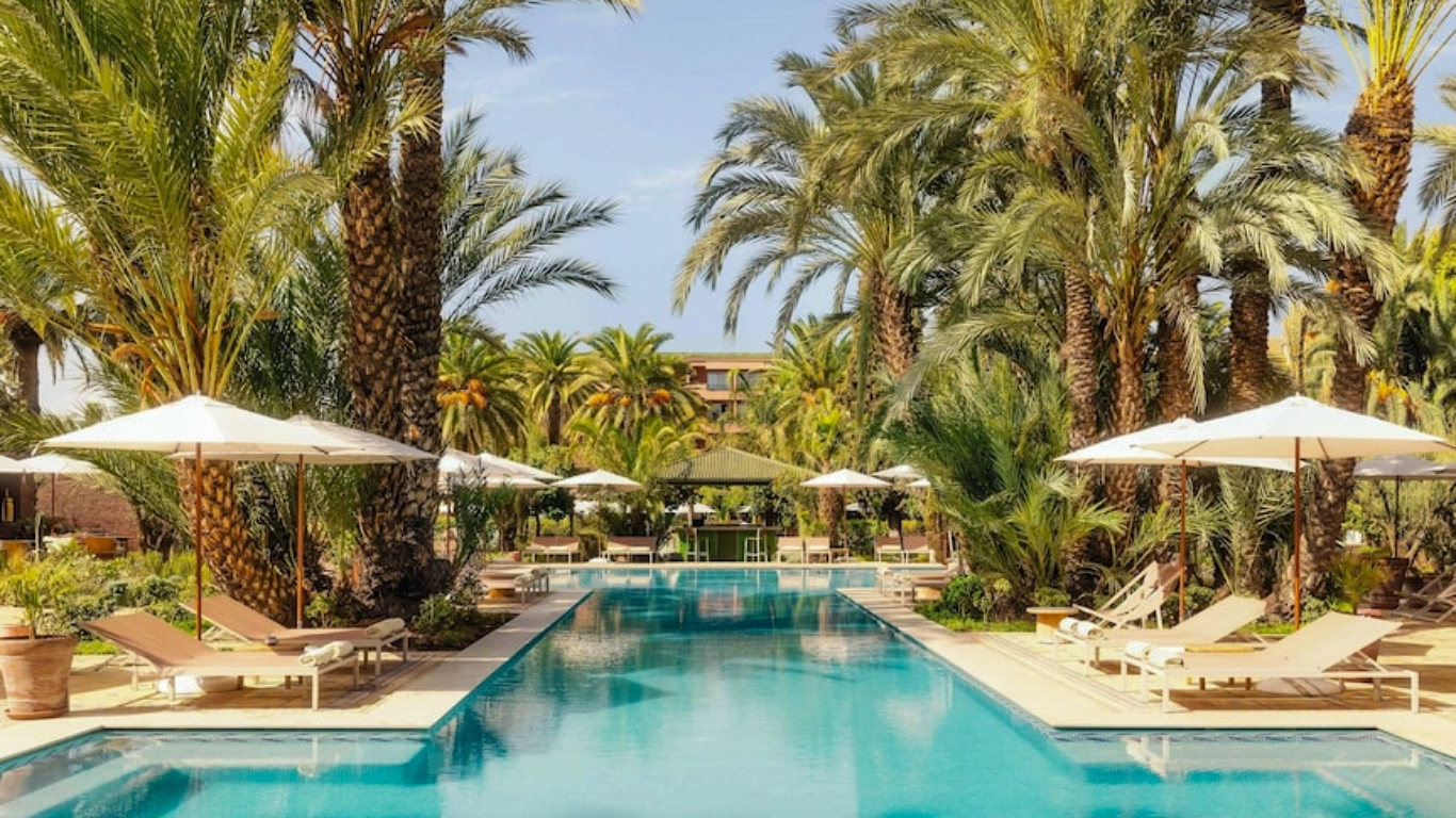 Outdoor pool with palm trees and sun loungers at Sofitel Marrakech Palais Imperial & Spa all inclusive hotel