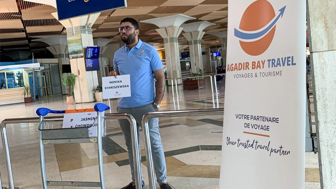 Private marrakech airport transfer representative holding a sign for arriving guests at a spacious terminal.
