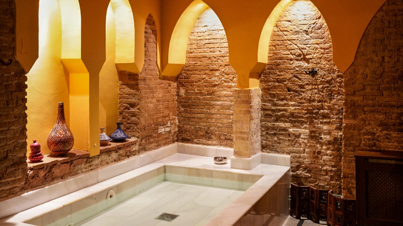 Interior of a traditional Moroccan hammam with warm lighting and decorative tiles
