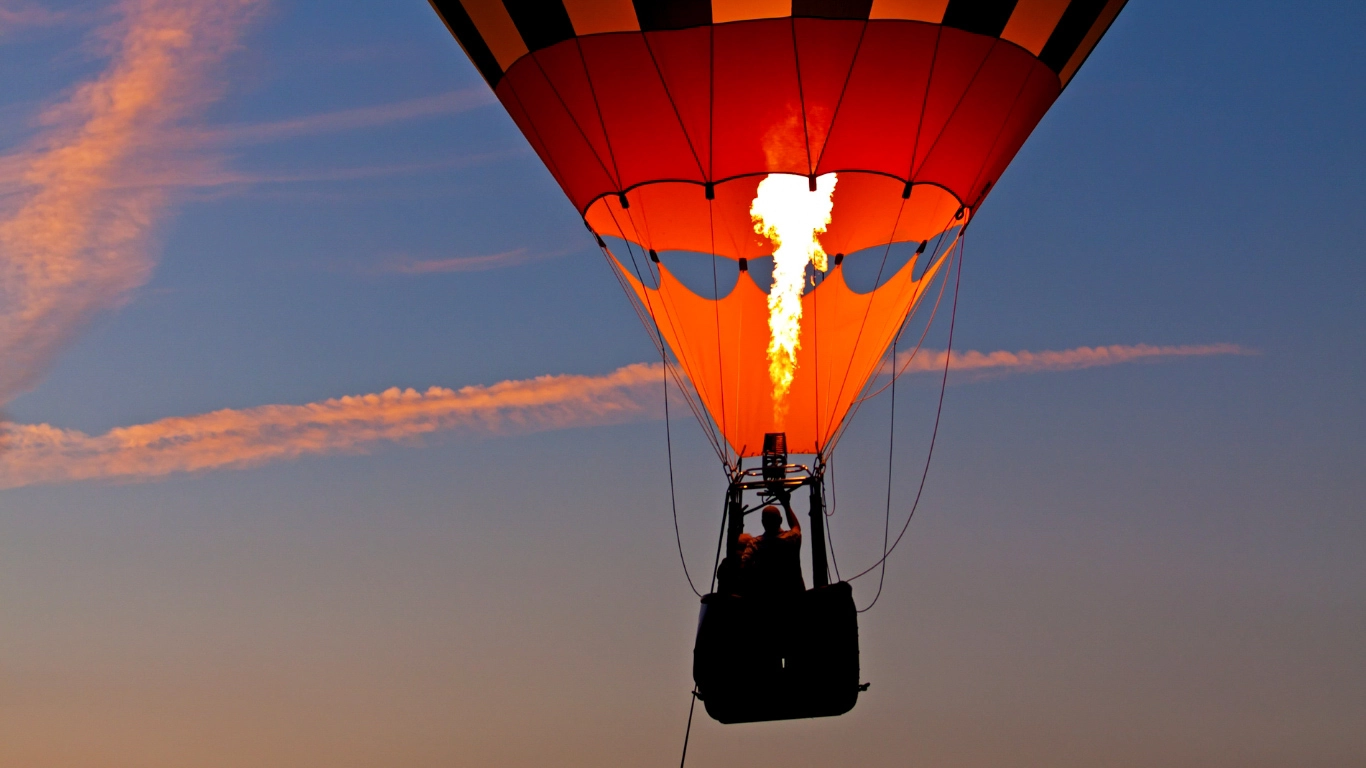 Hot air balloon inflating at sunrise over the Marrakech landscape