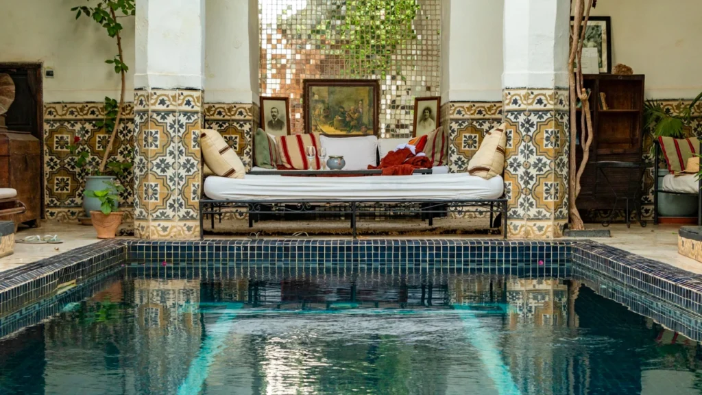 Interior of a traditional Moroccan riad with a pool and decorative tiles