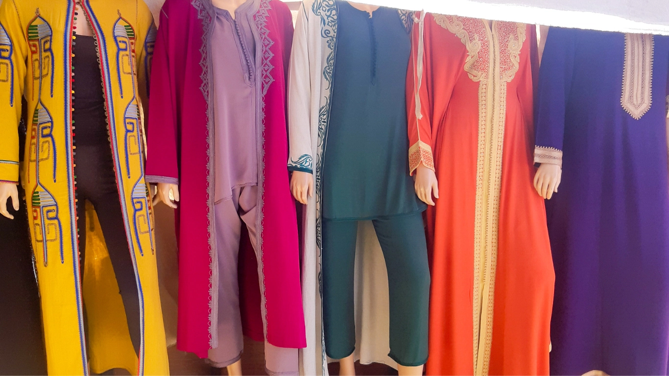 Vibrant display of colorful Moroccan garments in a market, showcasing traditional fabrics and styles to buy in Marrakech.