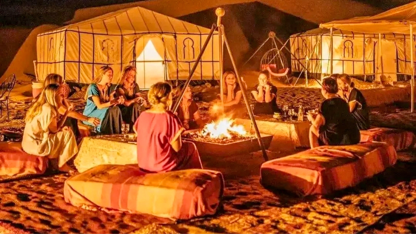 Friends sitting around a campfire at a luxury desert camp in Agafay near Marrakech
