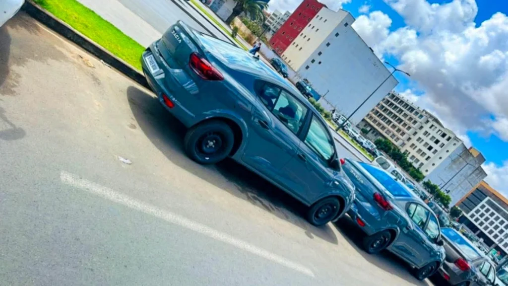 Row of grey Dacia Logan rental cars parked on a sunny street in modern Marrakech, ideal for budget travelers looking for the cheapest car hire without a deposit.