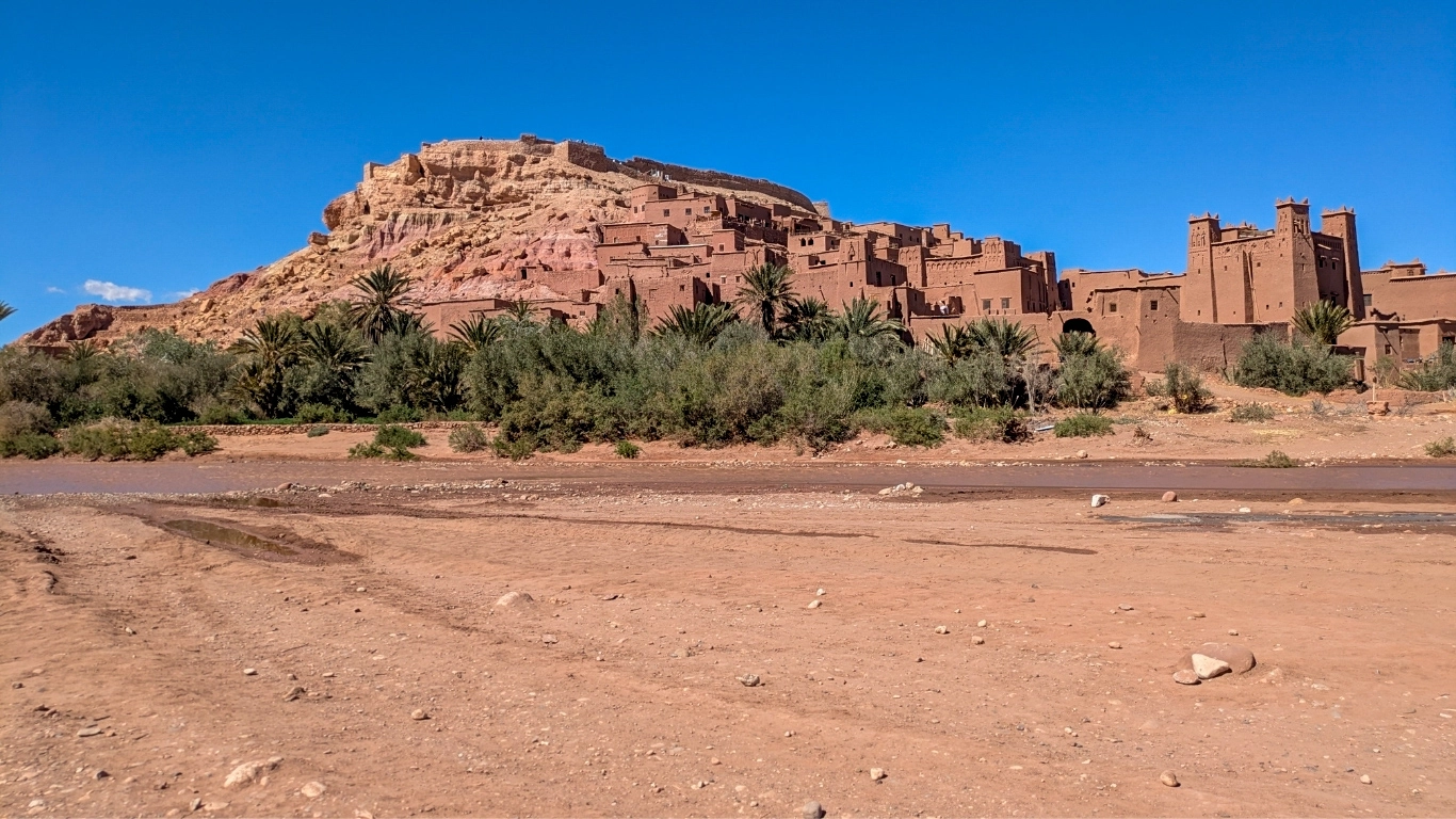 Aït Ben Haddou kasbah, UNESCO World Heritage site in Morocco, with earthen towers and mud-brick buildings on a rocky hill.