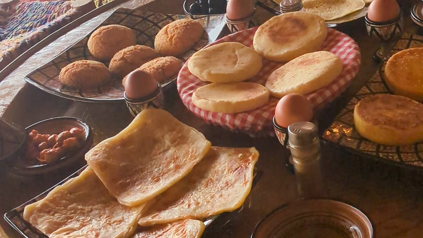Traditional Berber breakfast served in a tent after a hot air balloon flight near Marrakech, Morocco, with Moroccan pancakes, khobz bread, and eggs.